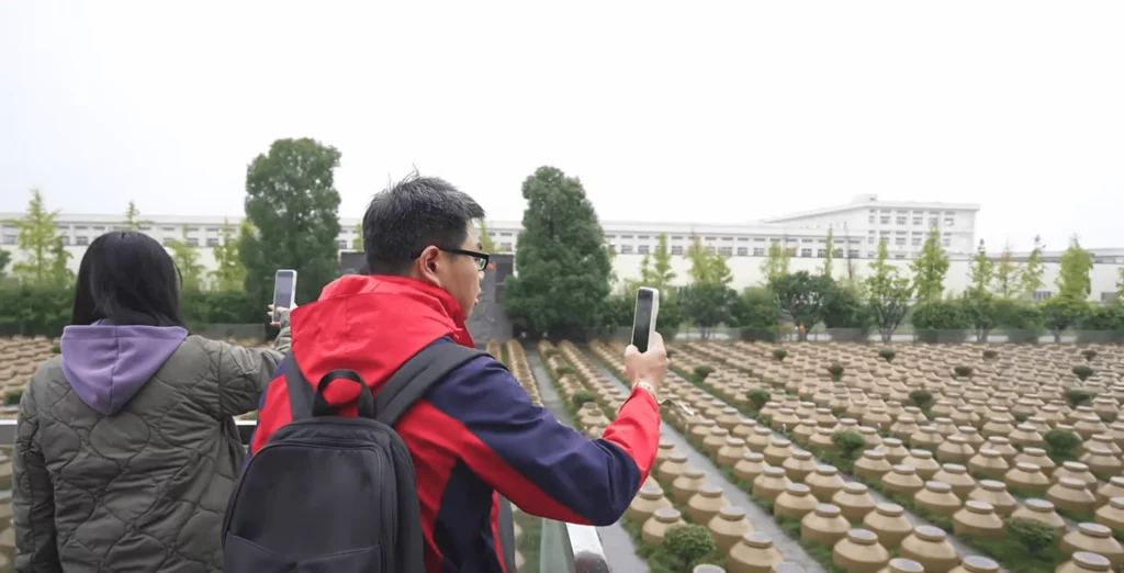 The media takes photographs of Qianhe Brewing jars.